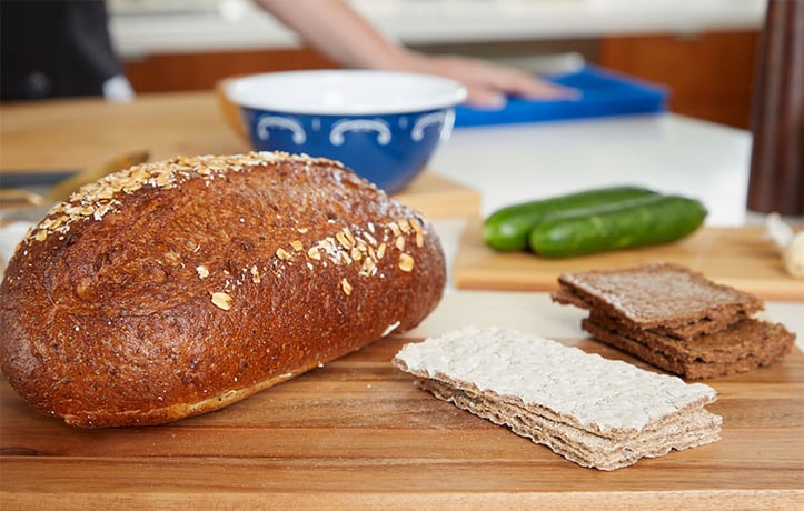 Loaf of bread with crackers on a wood cutting board