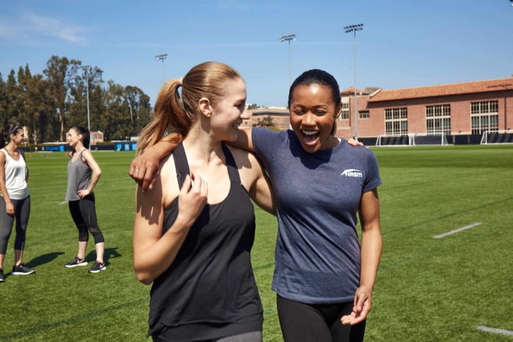 Female NASM trainer with arm around female client walking