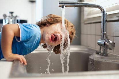 Child drinking water from faucet