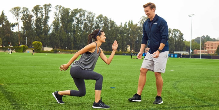 Personal trainer working with client outdoors