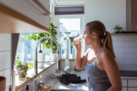 Woman drinking water in kitchen