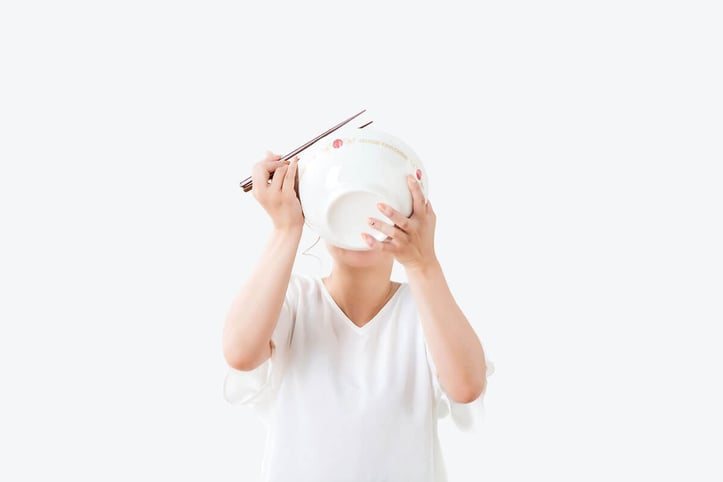 A woman drinking soup out of a bowl