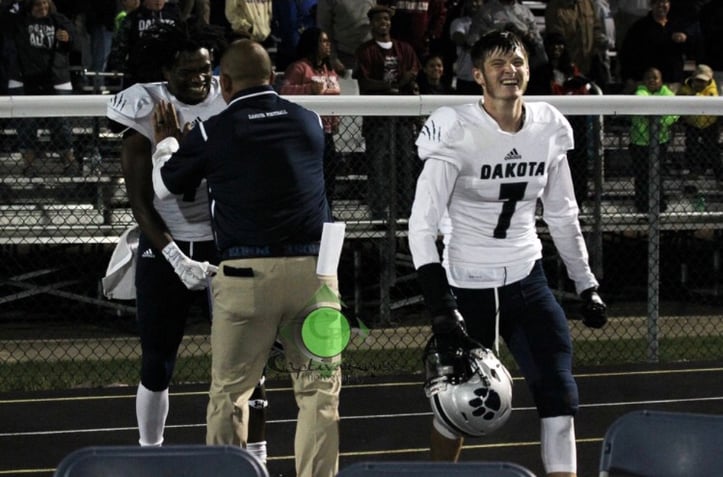 Coach cheering on football players