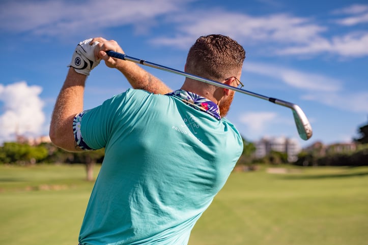 man swinging a golf club outside