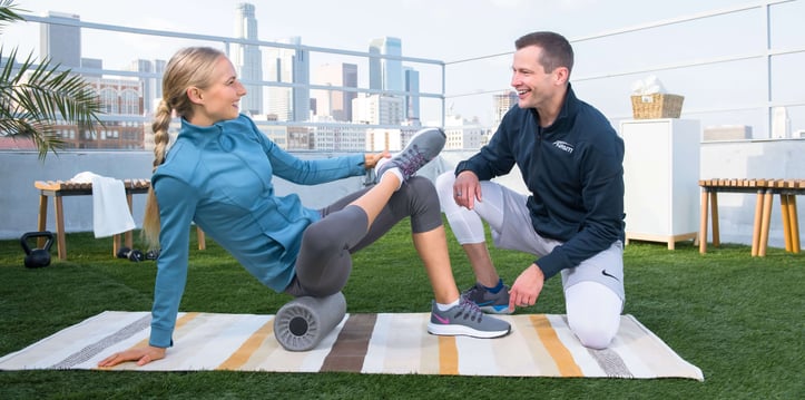 Rick Richey assisting client on foam roller stretch