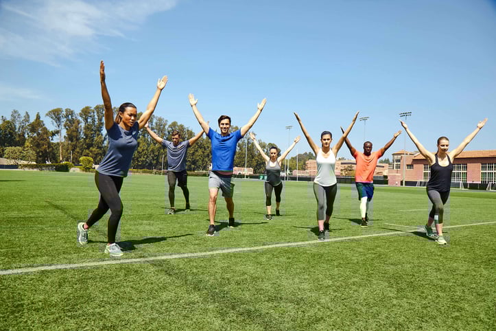 Group workout class doing exercise outdoors