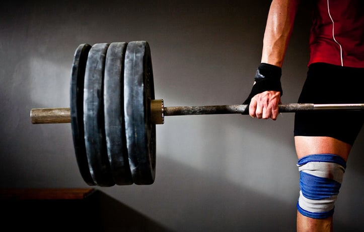 Weightlifter lifting barbell with 4 plates