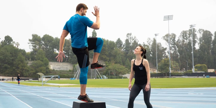 Personal trainer working with client outdoors