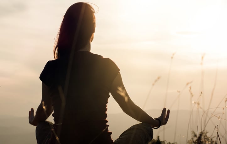 A lady meditating in a field