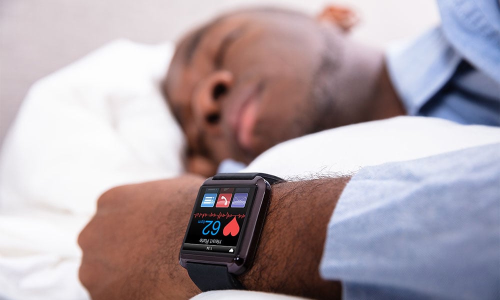 man with a fitness wearable device asleep