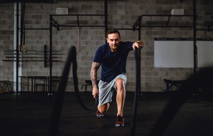 a man using the ropes in a gym