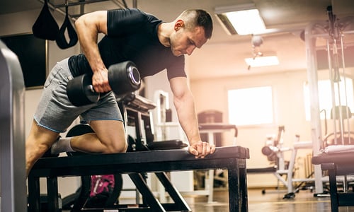 a man doing dumbbell rows in the gym