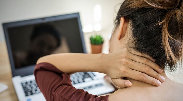 Woman grabbing at her neck seems to be in pain