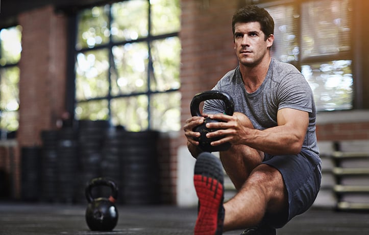 a man doing a functional training kettlebell squat
