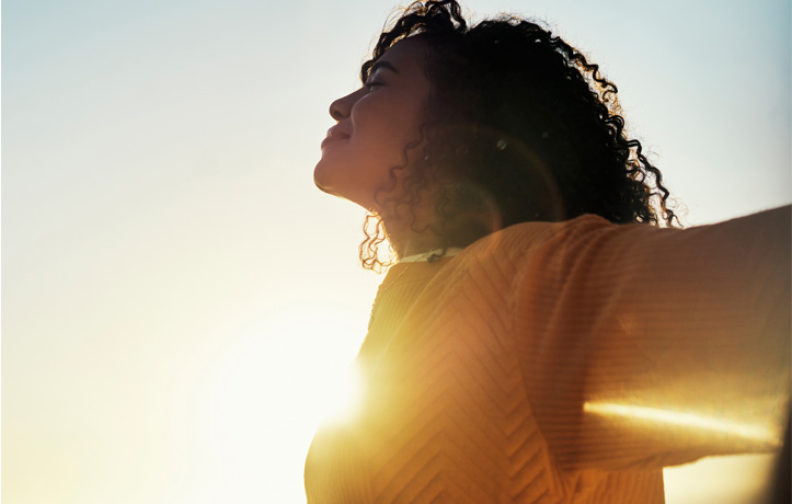 A woman taking a deep breath outside