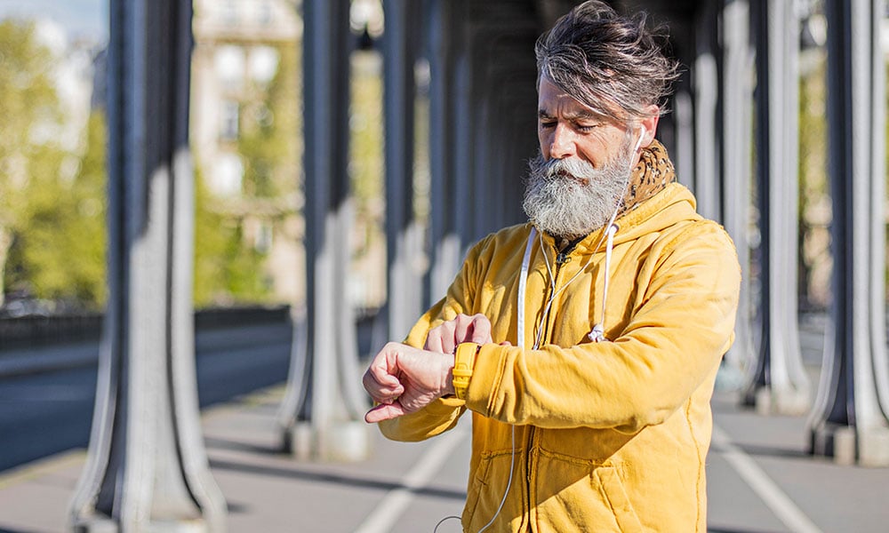 man using a health tracker before a run