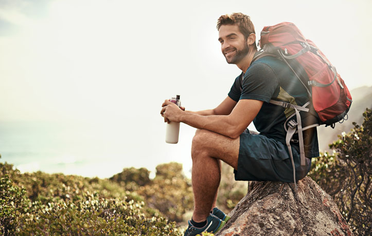 A man sitting on a rock in nature