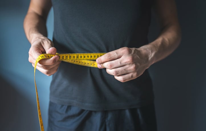 a man measuing his belly fat