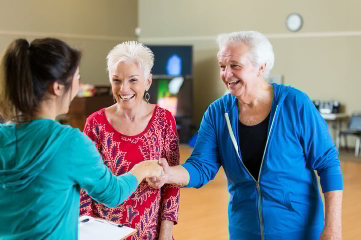 Elderly couple shaking hand with female