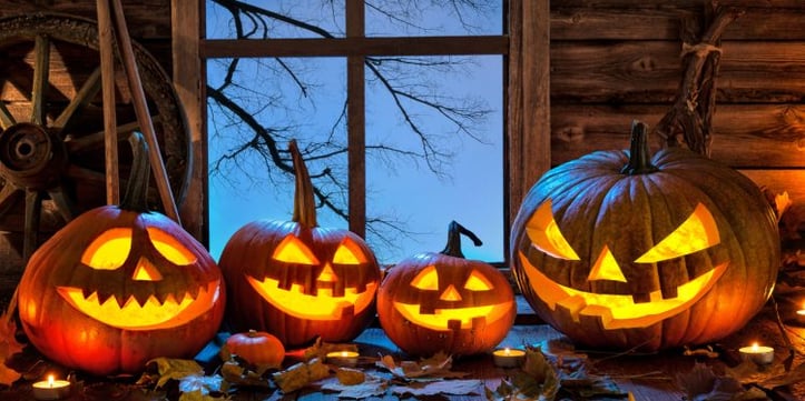 Carved halloween pumpkins sitting next to window seal