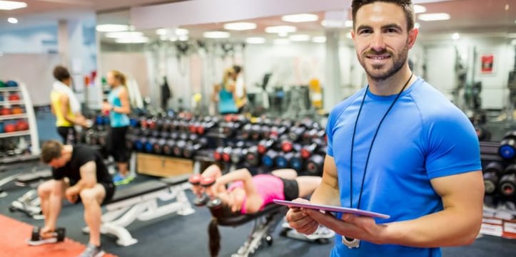 Trainer with a clip board in a gym