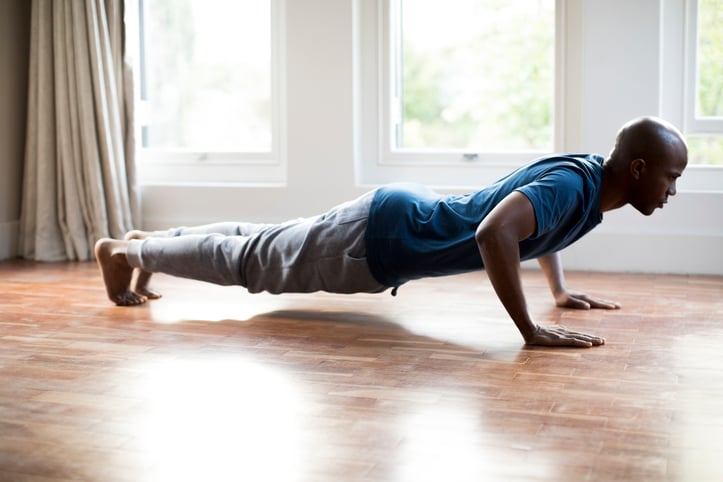 Male doing push up inside home