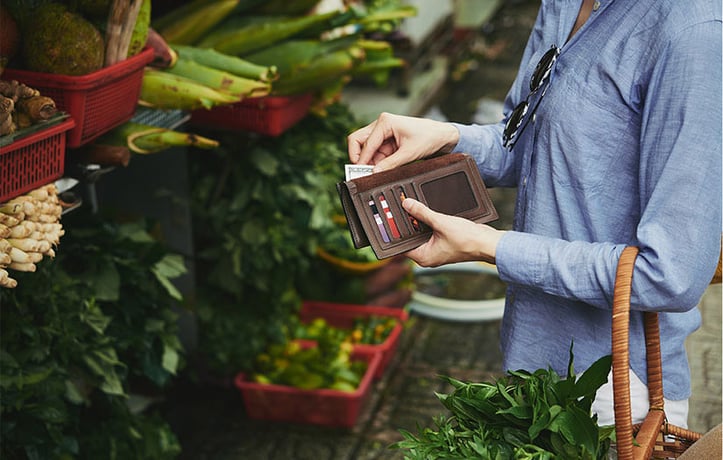 woman buying produce at a grocery store