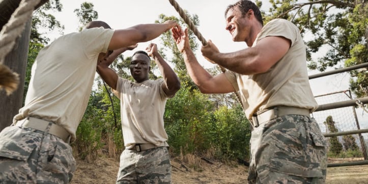 Soldiers high fiving during a obstacle course 