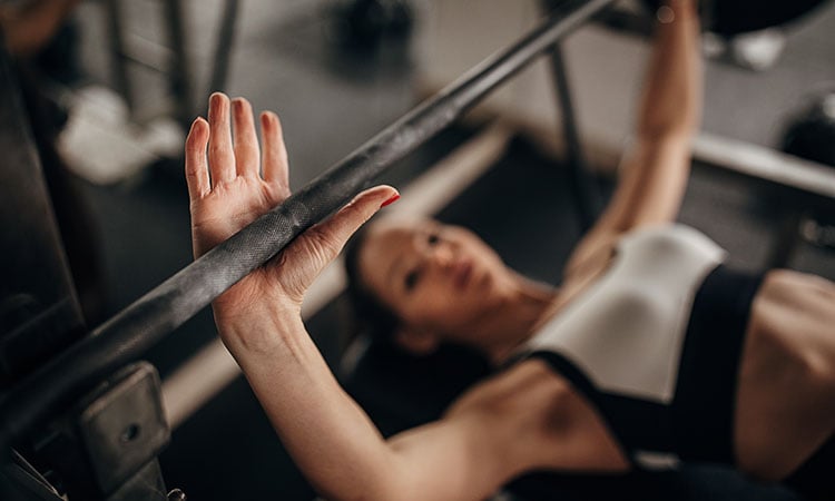 a woman bench pressing with neutral grip