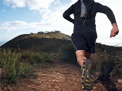 male running outside on a dirt trail