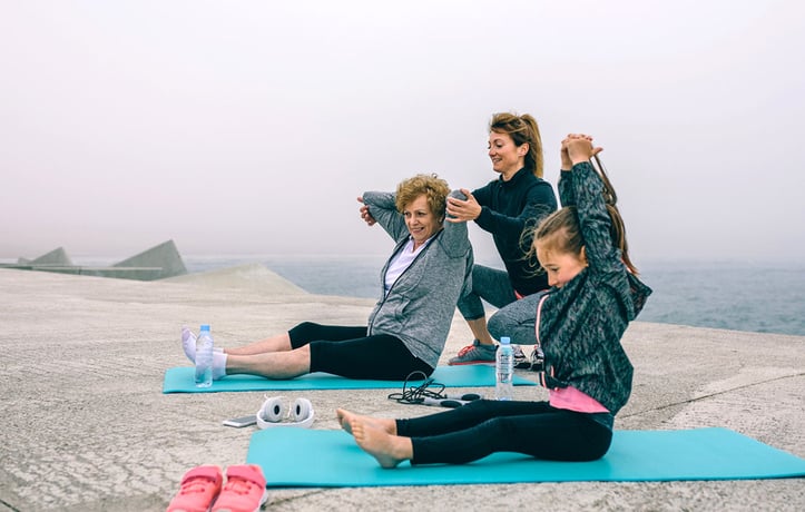 senior and kid doing yoga stretches outside