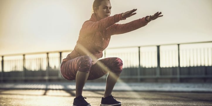 woman doing a squat outside
