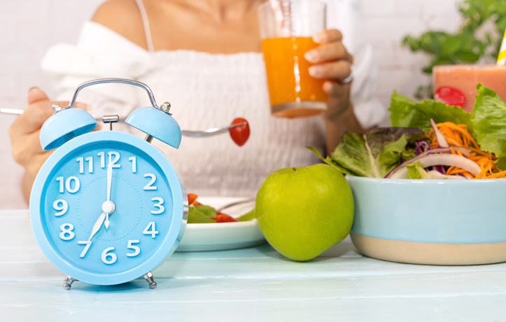 A table with fruits, vegetables and a clock