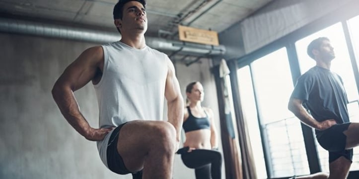 athletes doing forward lunge inside industrial gym