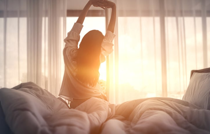 A Happy Woman Stretching on the Bed