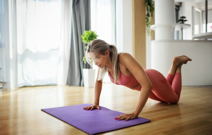 woman doing kneeling push up indoors