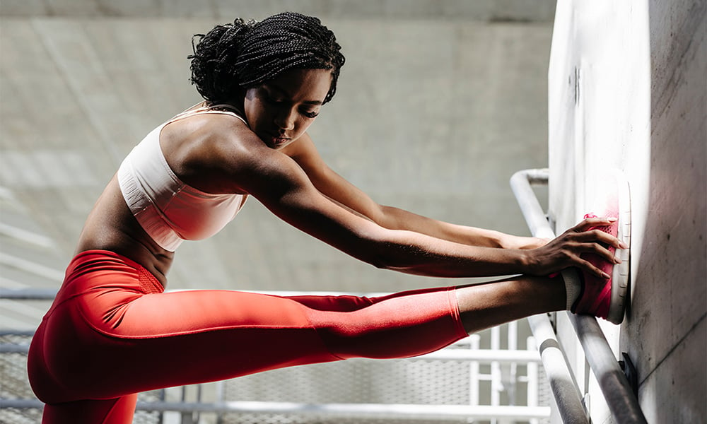 woman stretching against wall