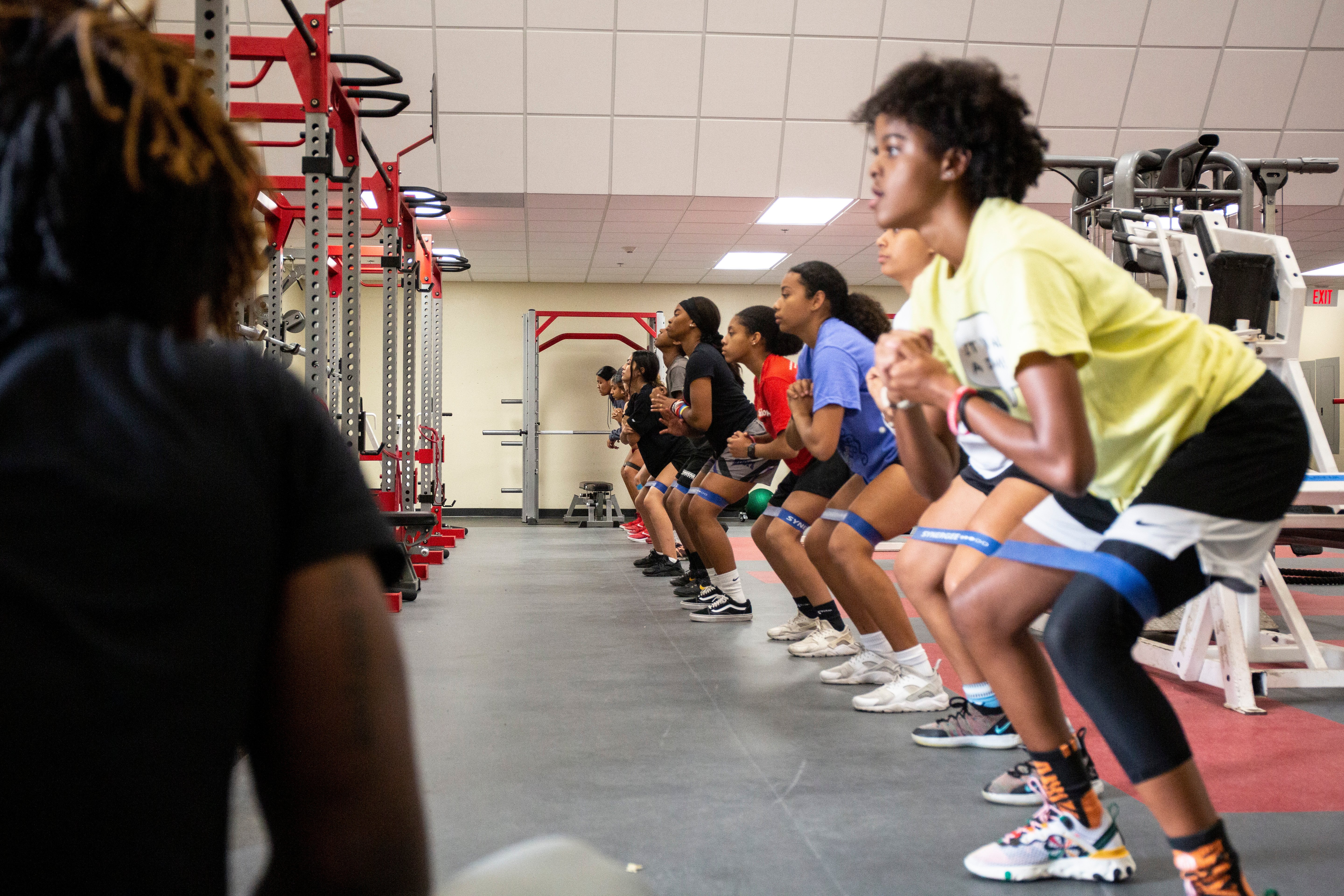 youth doing banded walks in a gym