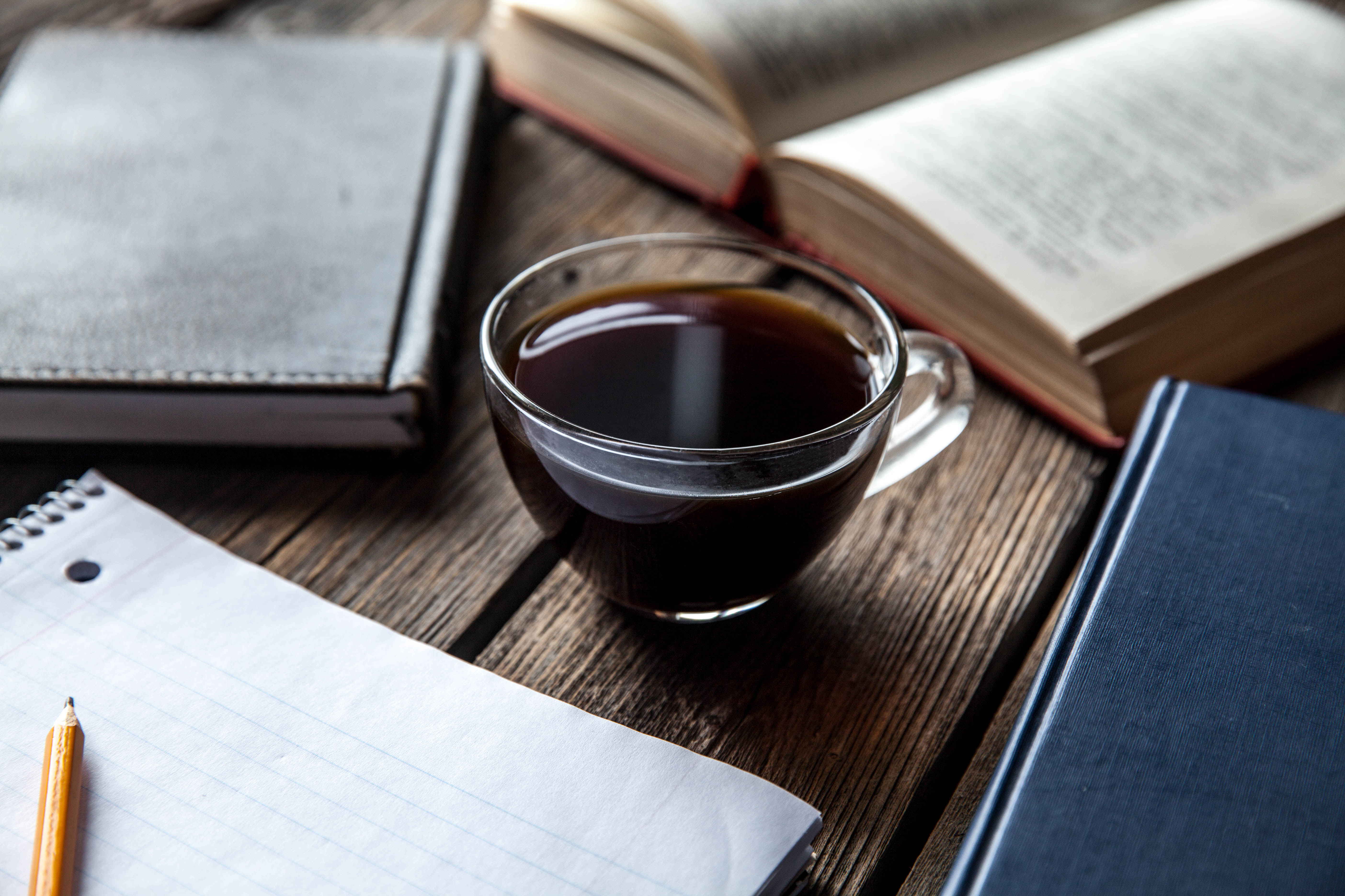 Cup of coffee on a table with books surrounding