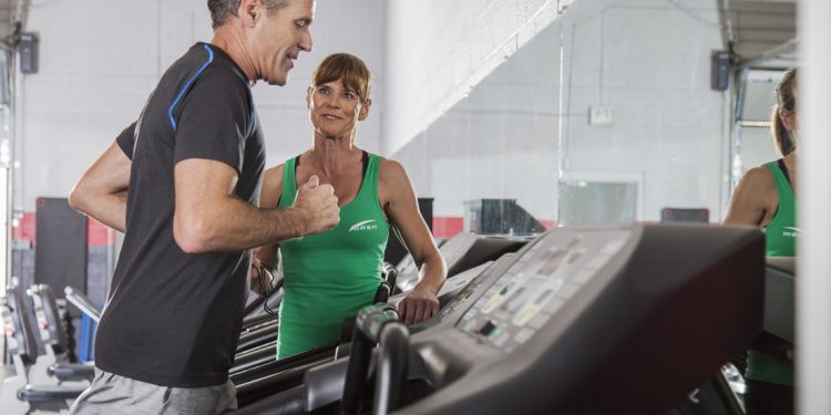 a personal trainer coaching a client on the treadmill