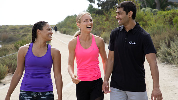 NASM Trainer walking with two clients outside