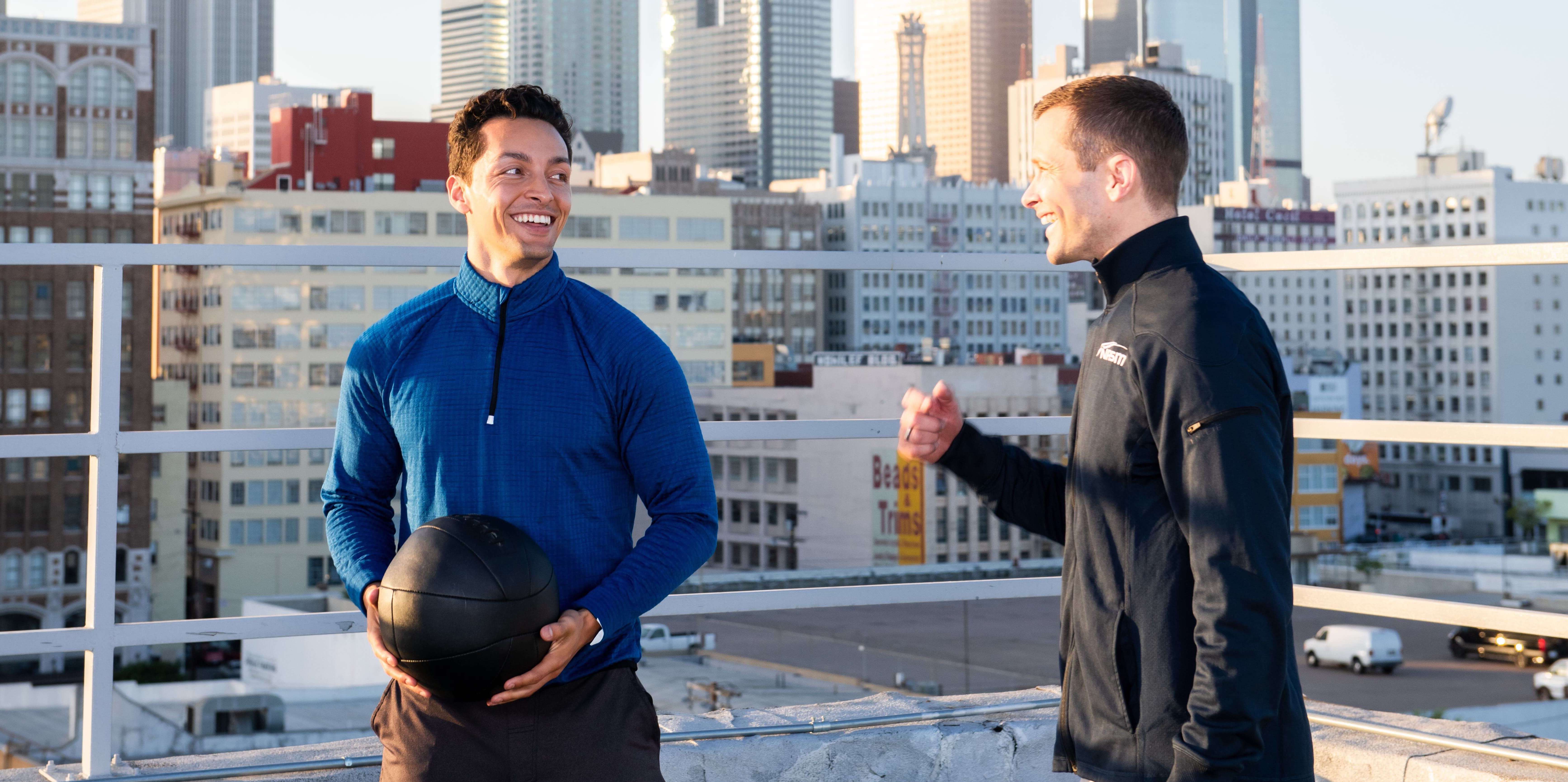Personal trainer talking to client holding medicine ball