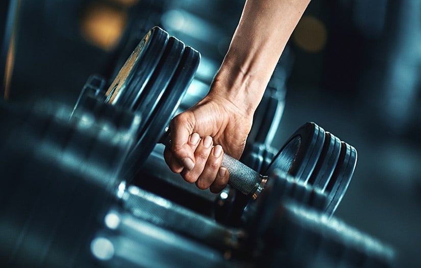 a man grabbing a dumbbell 