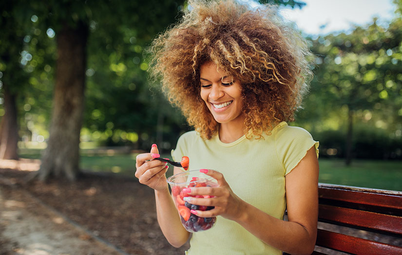 a woman eating nutritious foods outside to boost her mood
