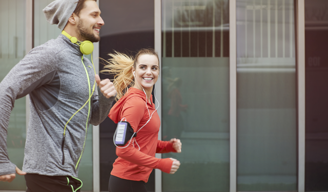 Man and woman wearing warm athletic clothes running outside