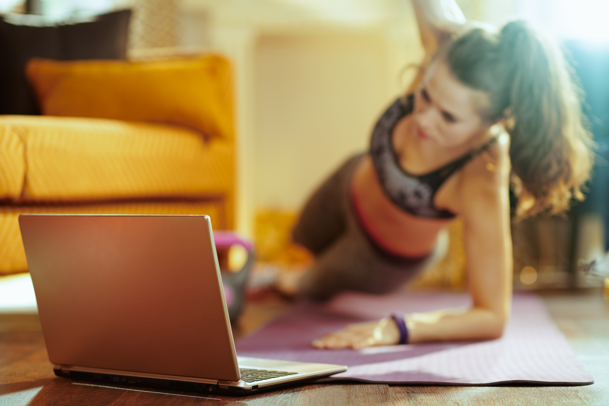 trainer doing online personal training in front of laptop camera