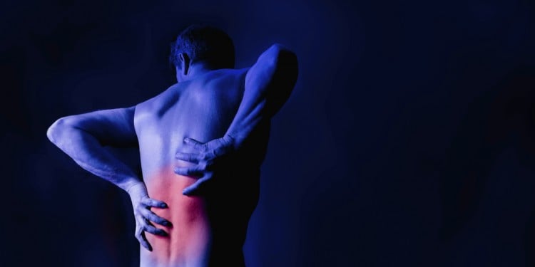 man clutching his lower back in pain