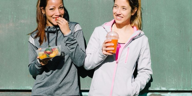 Two females enjoying fruit and juice together