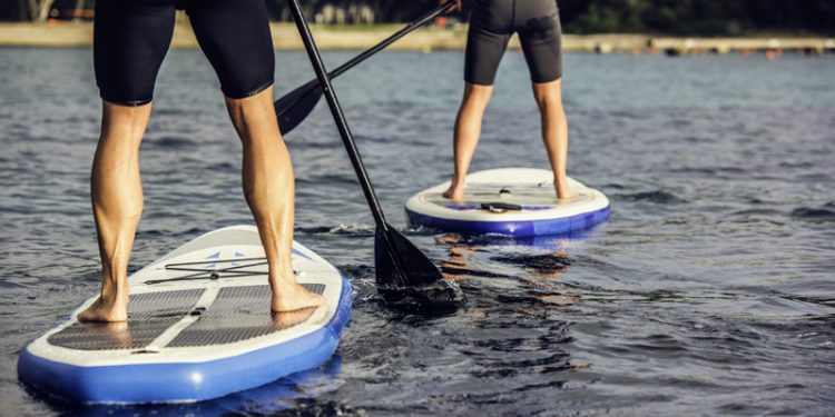 two people paddle boarding on water