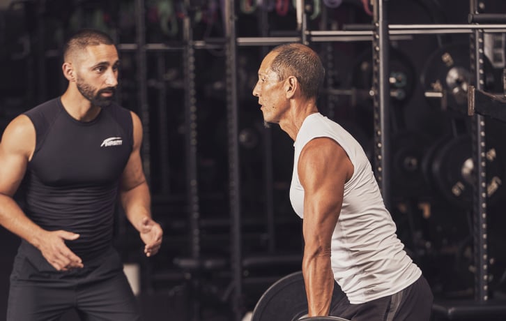 A male trainer helping a male client